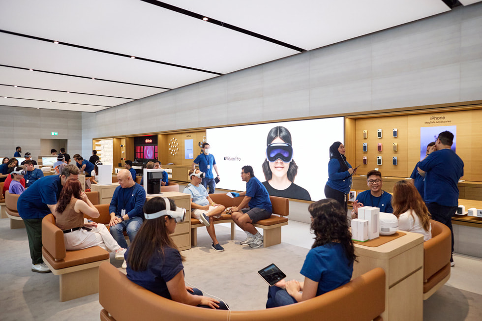 A zoomed-out look at the Demo Zone inside Apple Orchard Road, with customers and team members seated on curved benches.