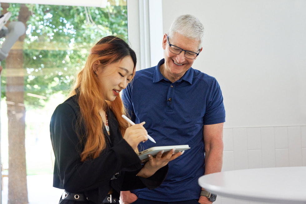 照片呈現 Tim Cook 與一名拿著 iPad 和 Apple Pencil 的學生開發者。