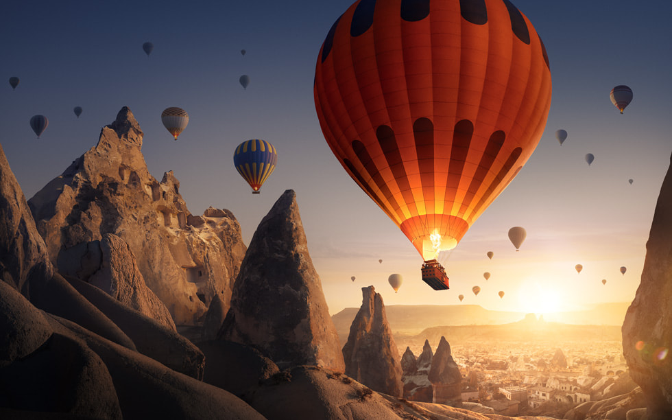 Ein Standbild aus „Boundless“ zeigt Heißluftballons, die über felsiges Terrain fliegen.
