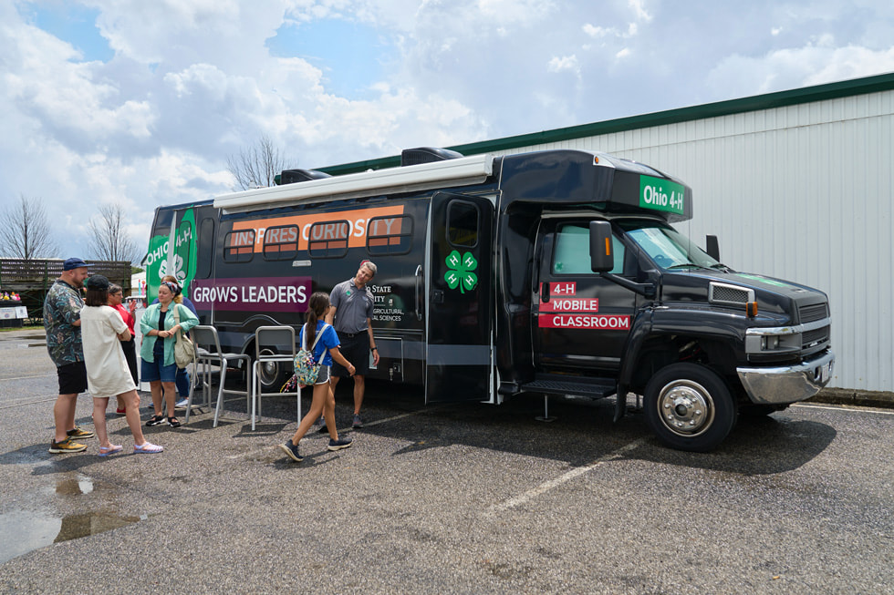 A crowd of young people outside the 4-H mobile classroom bus.