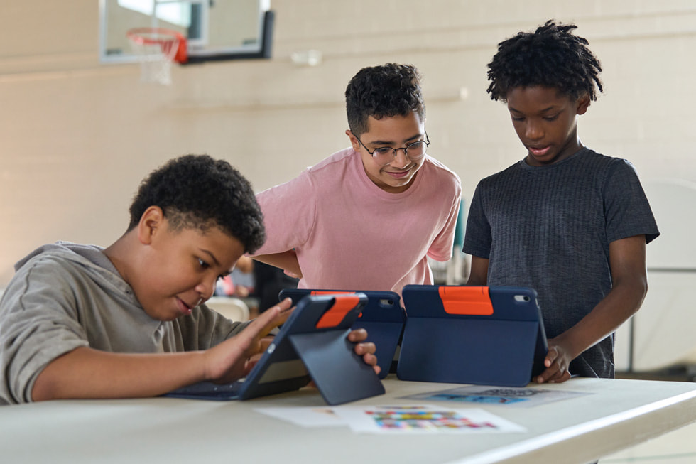 A 4-H instructor works with young learners using iPad at the STEM Explorers camp.