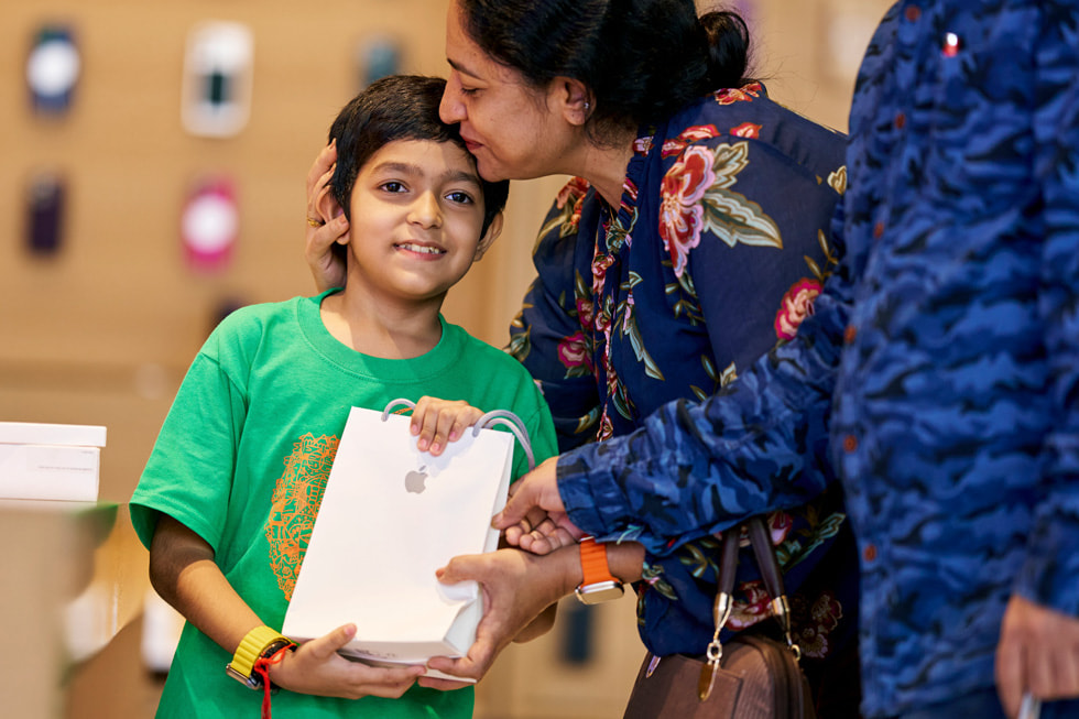 A young customer holds a bag containing their new purchase at Apple BKC in Mumbai.