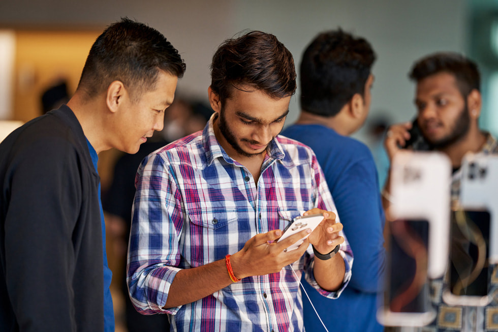 A team member assists a customer with iPhone 16 Pro at Apple BKC in Mumbai.