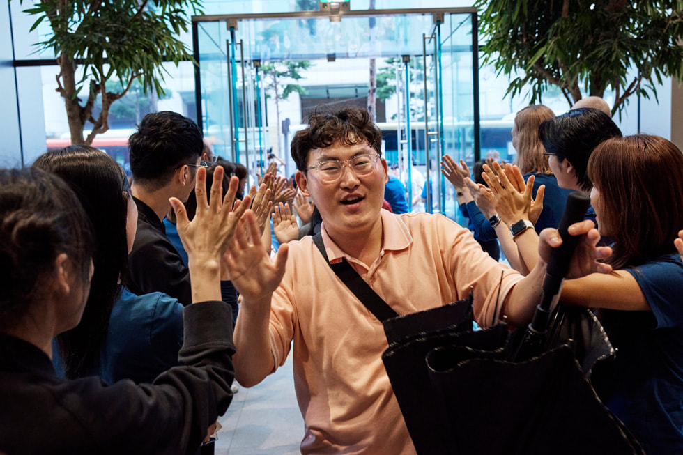 Apple team members applaud the first customers at Apple Myeongdong in Seoul, South Korea.