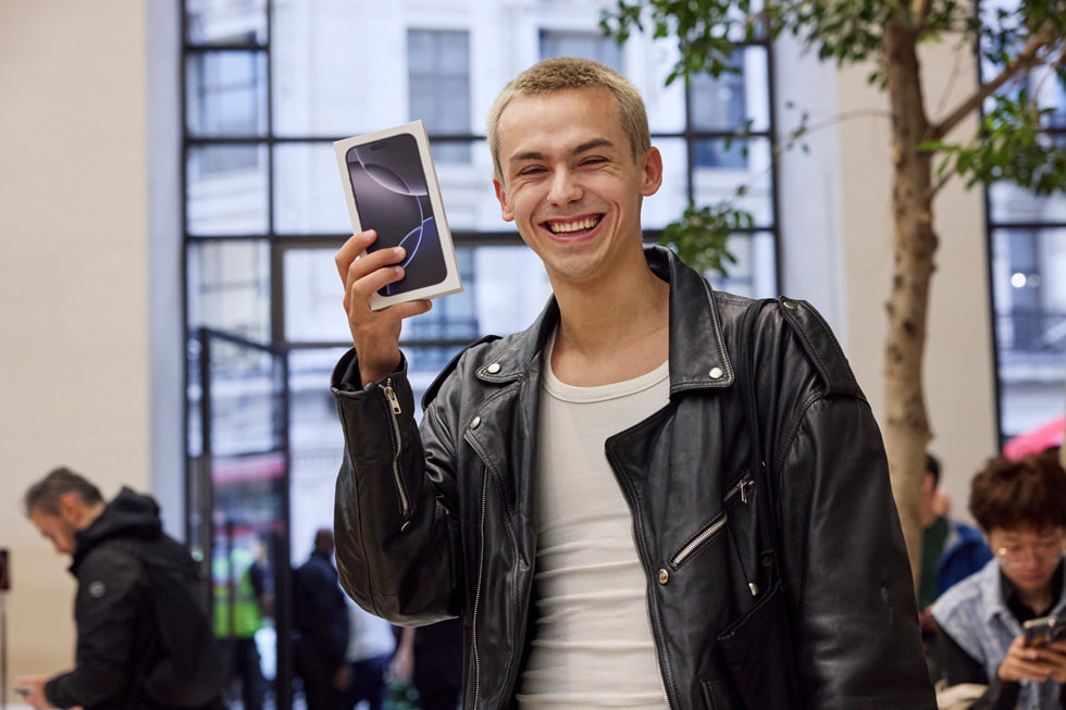 A customer poses with their iPhone 16 purchase at Apple Regent Street in London.