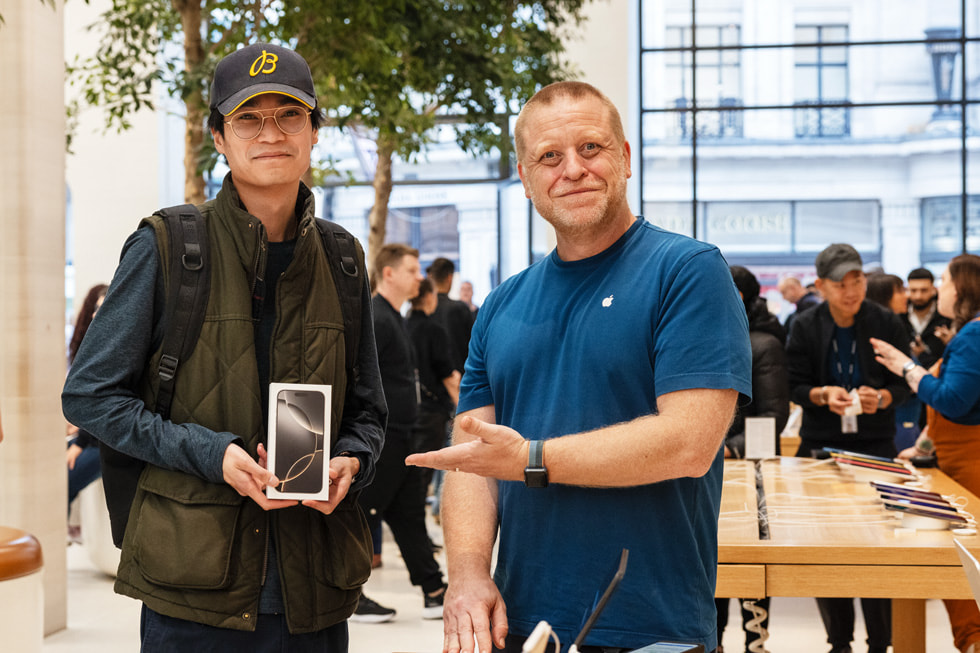 A customer poses with their iPhone 16 Pro purchase and a team member at Apple Regent Street in London.