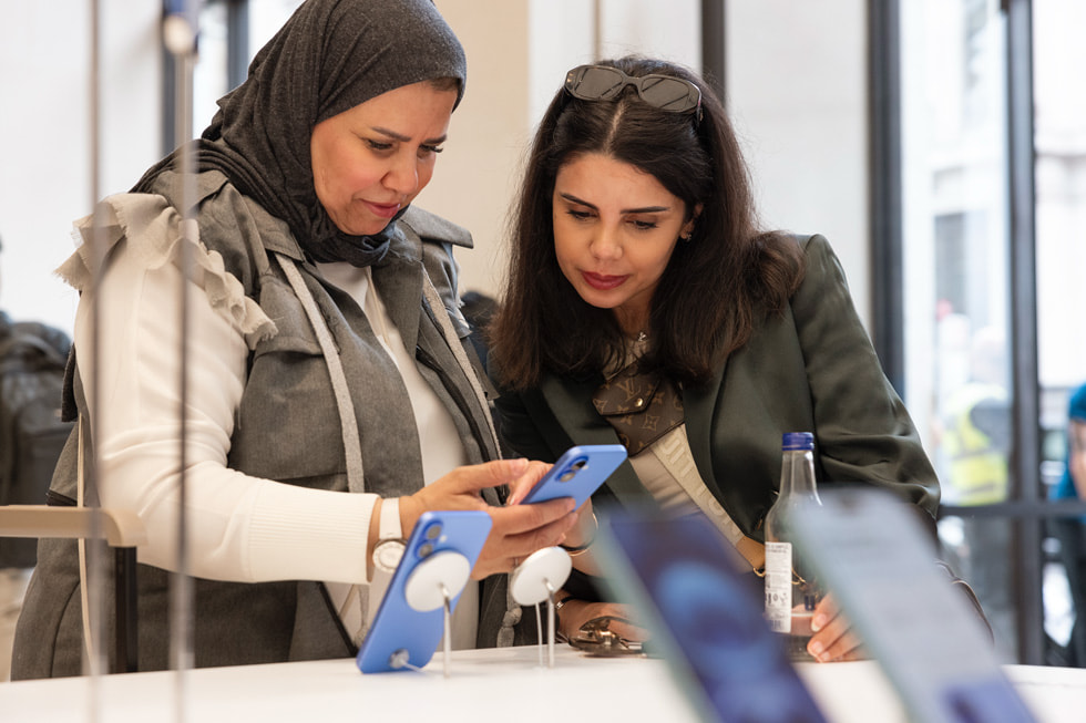 Two customers explore the new iPhone 16 devices at Apple Regent Street in London.