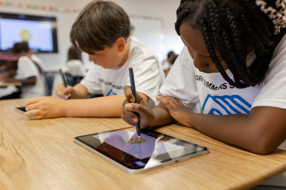 A student practices coding on iPad with Boys & Girls Clubs of America staff.