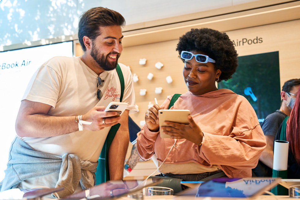 A customer explores Apple Pencil and iPad mini as another observes inside Apple Brompton Road.