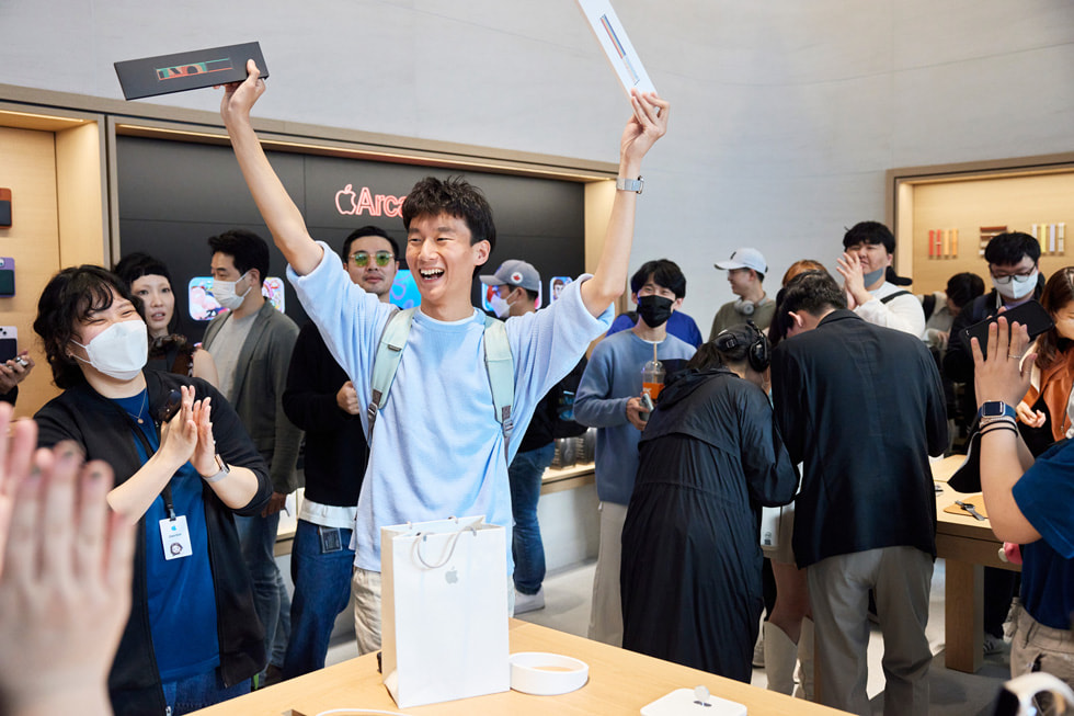 一位顧客與兩條 Apple Watch 錶帶在首爾的 Apple 江南零售店合影。