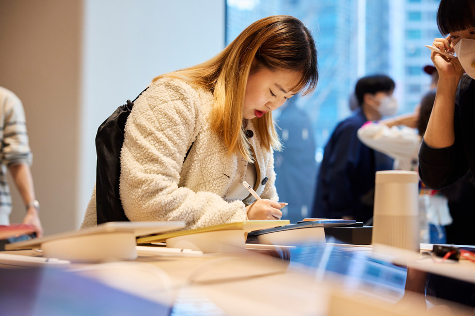 一位顧客在 Apple 江南零售店透過 iPad 探索 Apple Pencil。