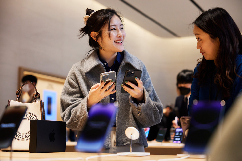 一位顧客在 Apple 江南零售店舉起新的 iPhone 14 Pro。