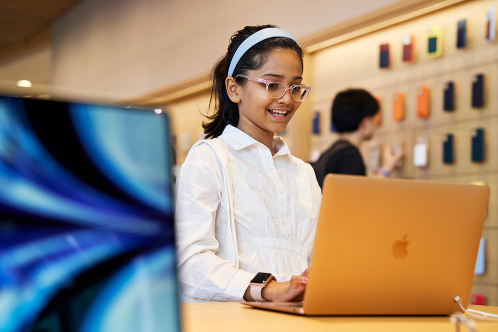 Une jeune cliente utilise un MacBook Air à la boutique Apple BKC.