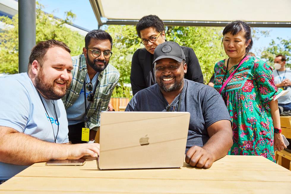 أحد المهندسين في Apple يقدم عروضاً توضيحية لمجموعة من الحاضرين في مؤتمر WWDC22 في Apple Park.