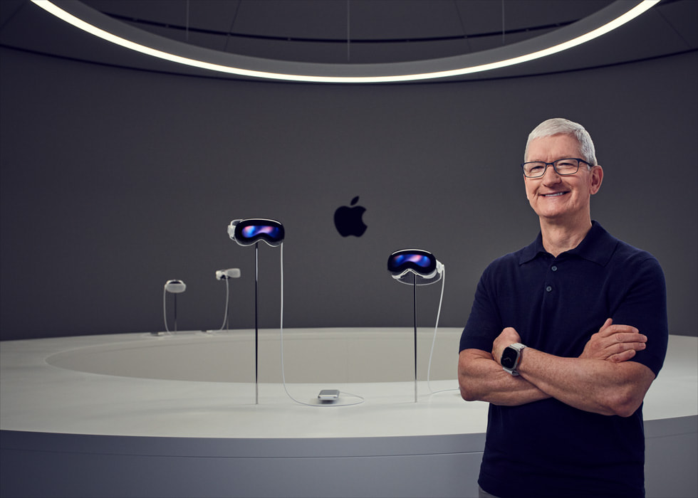 Apple 執行長 Tim Cook 站在 Apple Vision Pro 裝置展示台旁。