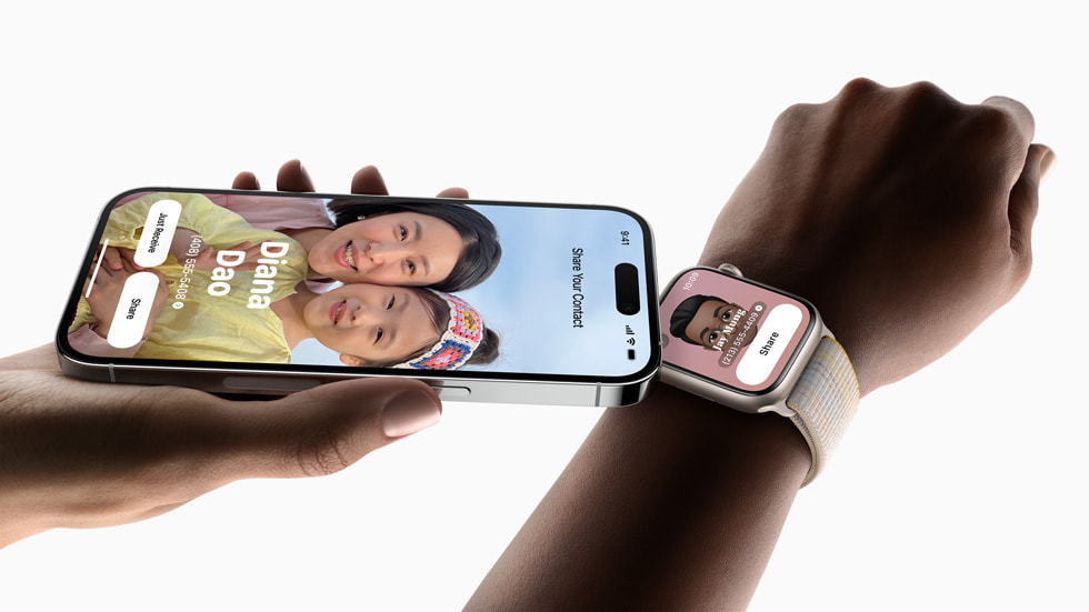 Een hand die iPhone 14 Pro vasthoudt en met NameDrop contactgegevens deelt met iemand die en Apple Watch Series 8 draagt.
