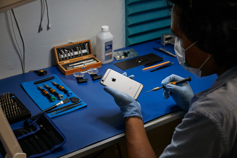 A repair technician performs a repair on an iPhone.