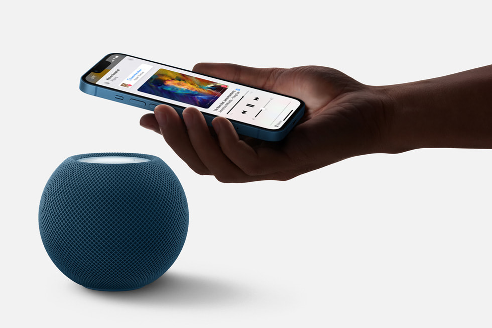 iPhone 13 being brought close to HomePod mini to hand off audio.