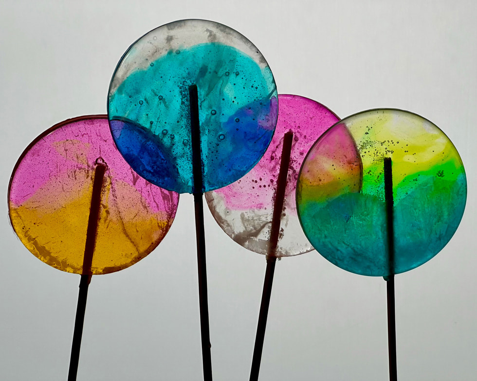 Four colorful lollipops are shot in close-up.