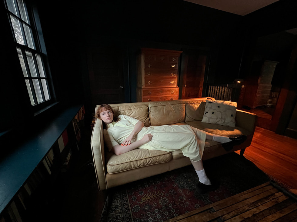 Kvinne som ligger på en sofa, tatt med ultravidvinkelkameraet på iPhone 13 Pro.