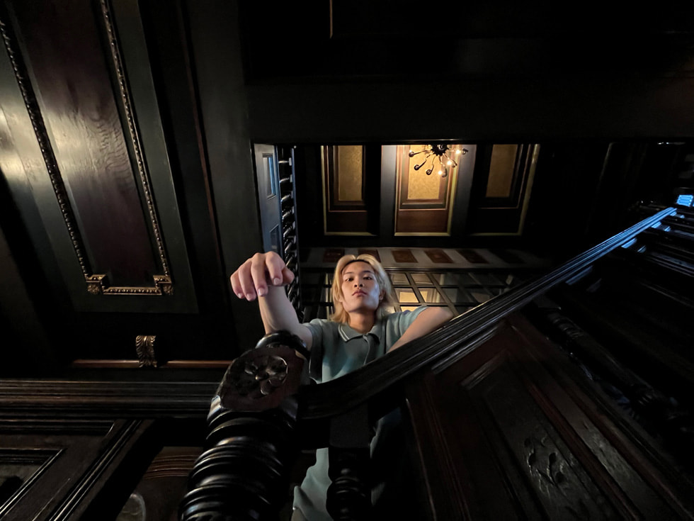 以 iPhone 13 的超廣角相機拍攝在陰暗樓梯上的男性肖像。