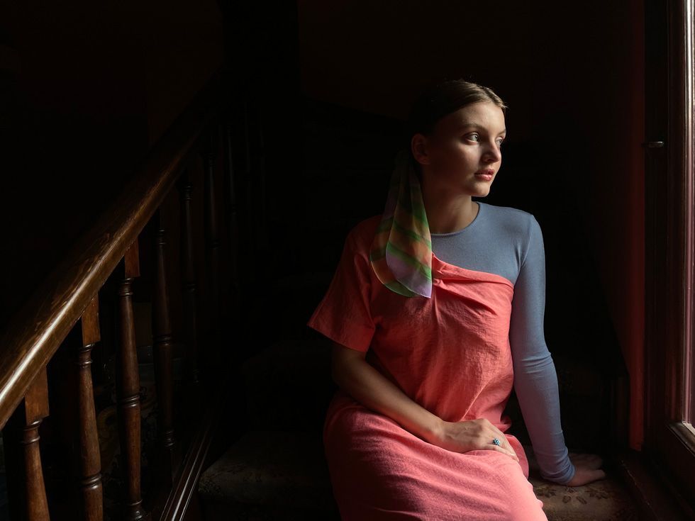Ett porträtt av en ung kvinna tagen inomhus i lågt ljus med iPhone 12.
