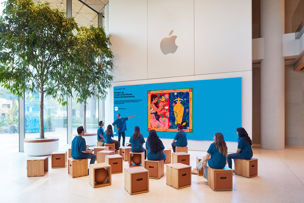 Der Forumsbereich von Apple BKC mit einer Videowand und Sitzgelegenheiten für Kund:innen.