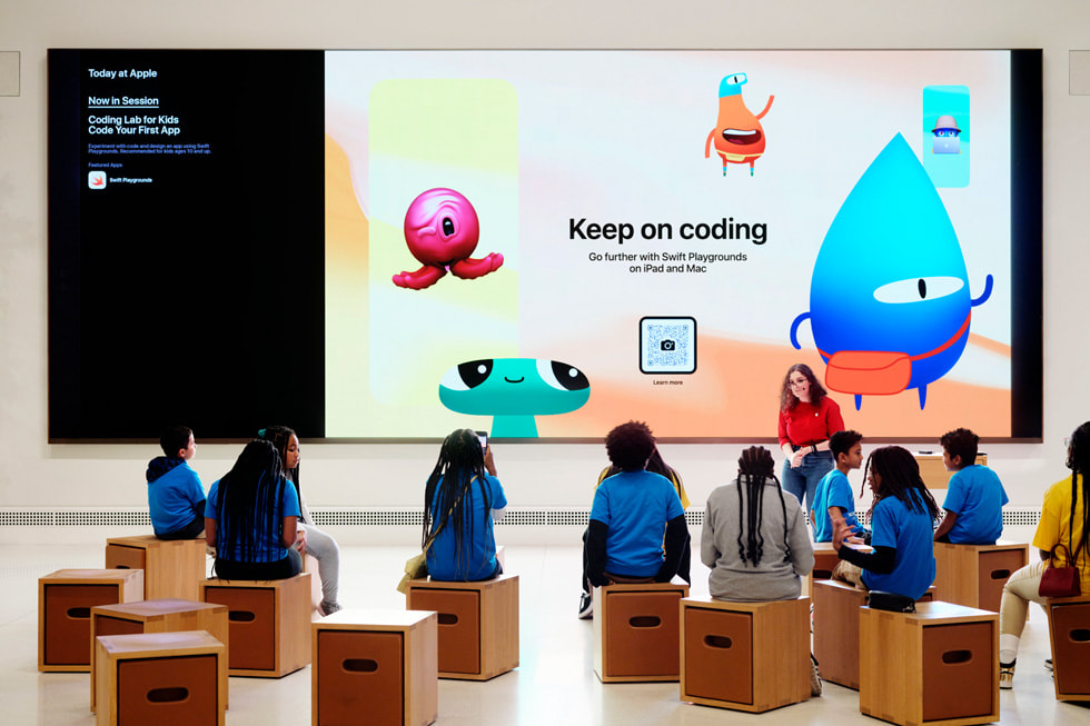 Estudiantes sentados en el Forum de un Apple Store en una sesión de Today at Apple titulada "Coding Lab for Kids: Code Your First App".
