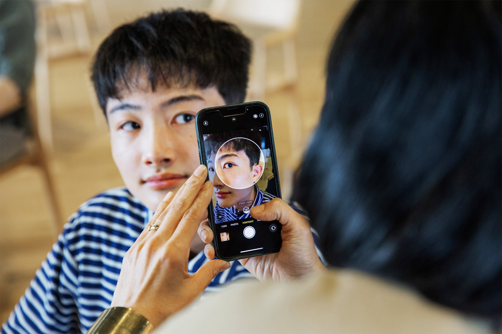 An Apple volunteer uses an iPhone to assist with the Creative Studios program in Tokyo.