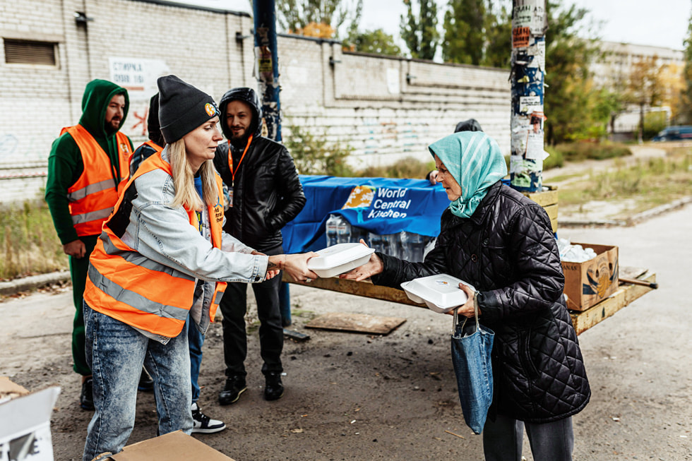 우크라이나에서 진행하는 월드센트럴키친 자원봉사 활동에 참여한 Apple 팀원이 음식을 나눠주는 모습.