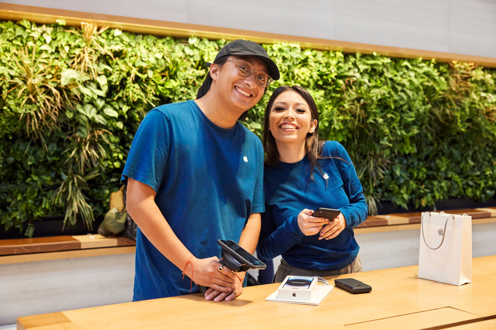 Especialistas de Apple sonriendo detrás de una mesa.