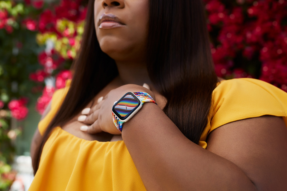 Primo piano di Dominique Morgan, attivista della comunità LGBTQ+, con al polso un Apple Watch con cinturino Solo Loop intrecciato e quadrante Pride Edition.
