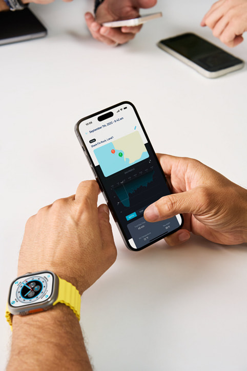Andrea Silvestri z założonym zegarkiem Apple Watch Ultra sprawdza aplikację pomocniczą Oceanic+ dla iPhone’a.