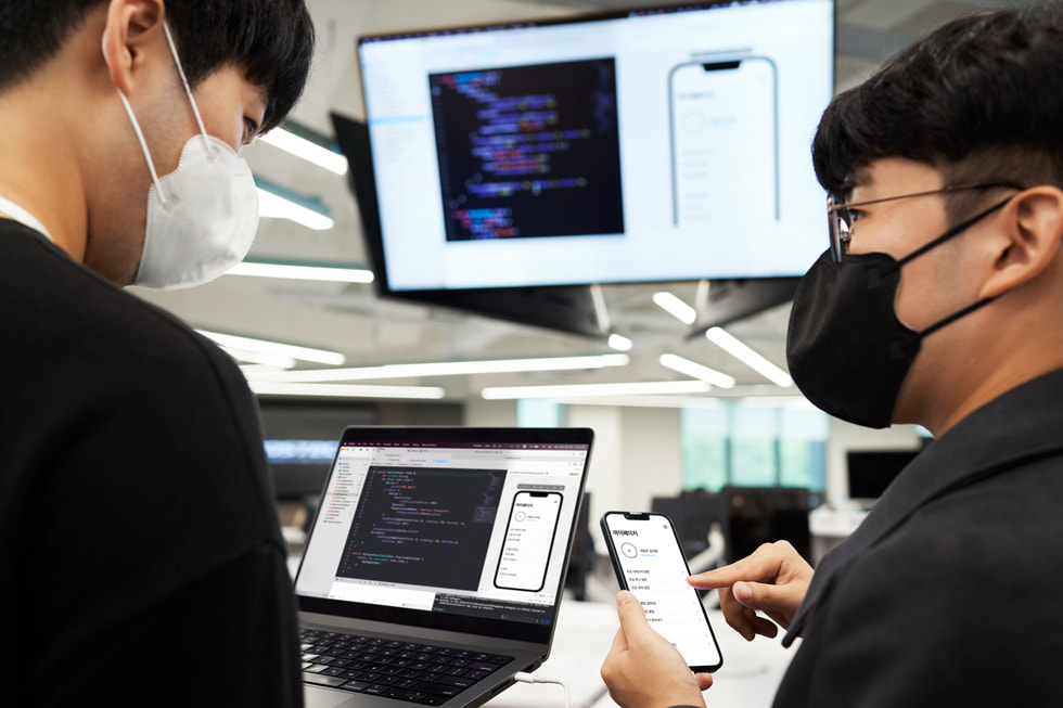 대한민국 포항시에 개소한 Apple Developer Academy에서 iPhone 화면을 바라보고 있는 두 학생의 모습.