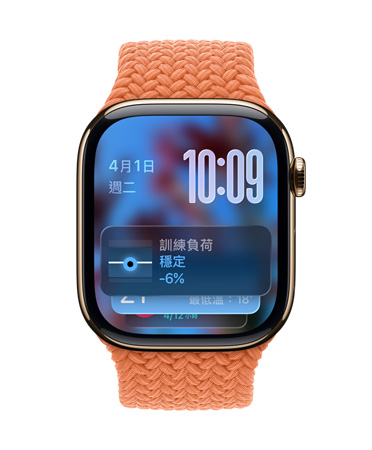 以金色鈦金屬打造的 Apple Watch,搭配橘紅色編織錶帶,錶面左上角顯示日期、右上角顯示以數字堆疊呈現的時間,底部顯示訓練負荷小工具,都以 Liquid Glass 的半透明風格呈現