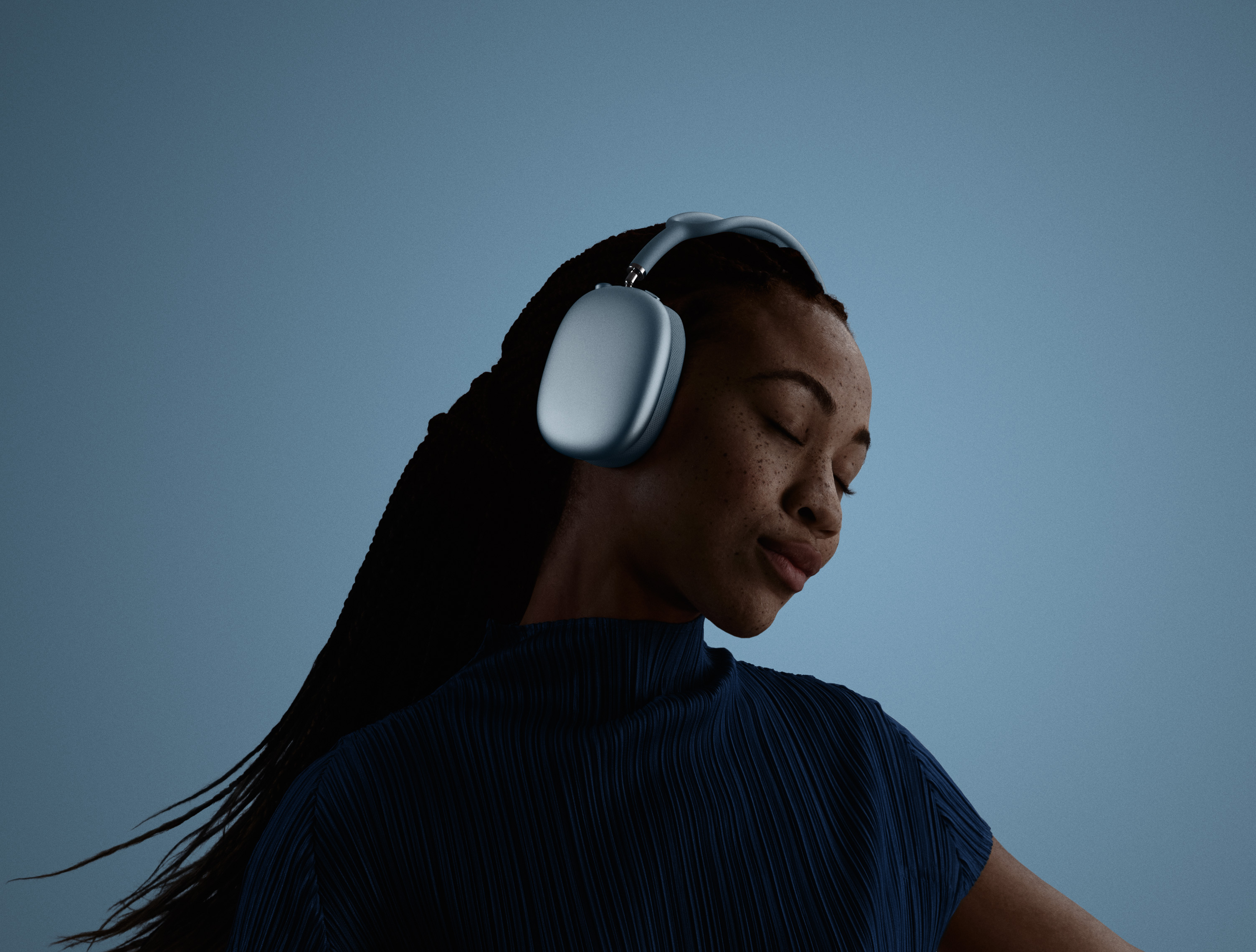 A woman with her eyes closed, and head tilted to the left, wearing AirPods Max.