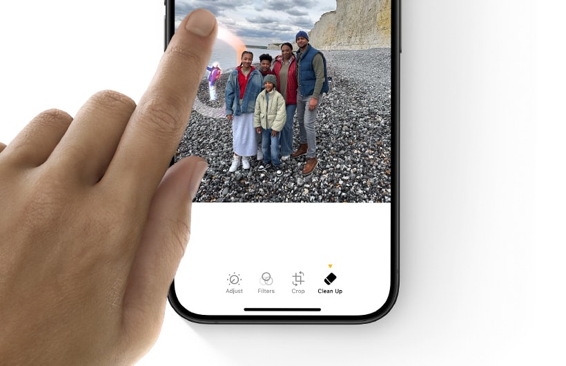 Un doigt touche un objet situé à l’arrière-plan dans une photo affichée sur iPhone pour indiquer ce qui doit être effacé