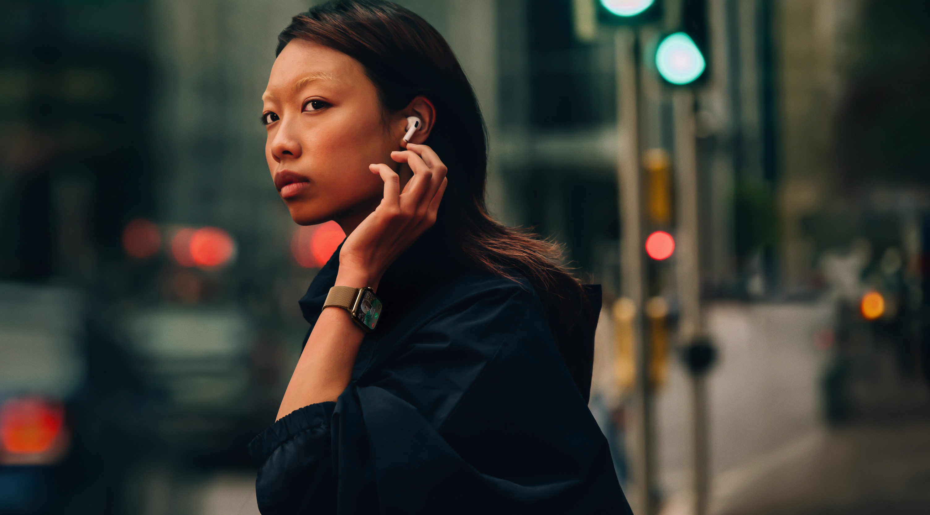 一位女士在街上，戴著 Apple Watch Series 10 和 AirPods。