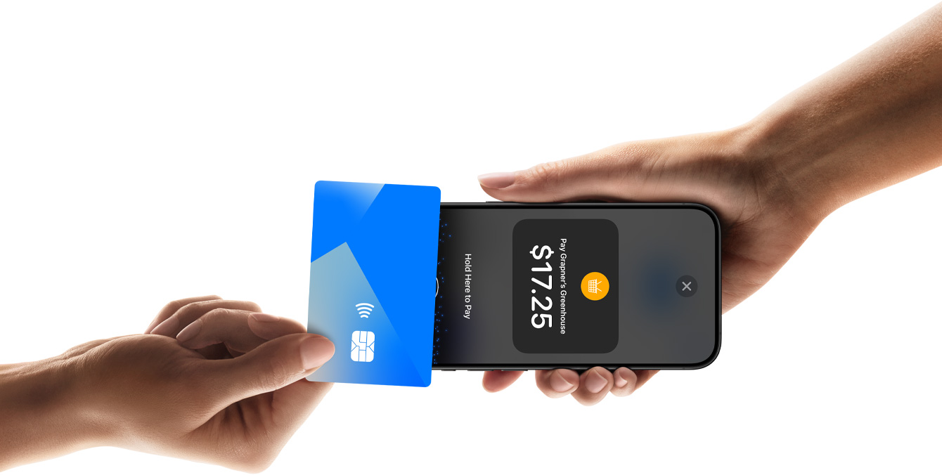 An image of a hand tapping a credit card on an iPhone device that another person is holding, with the iPhone's screen showing transaction information.