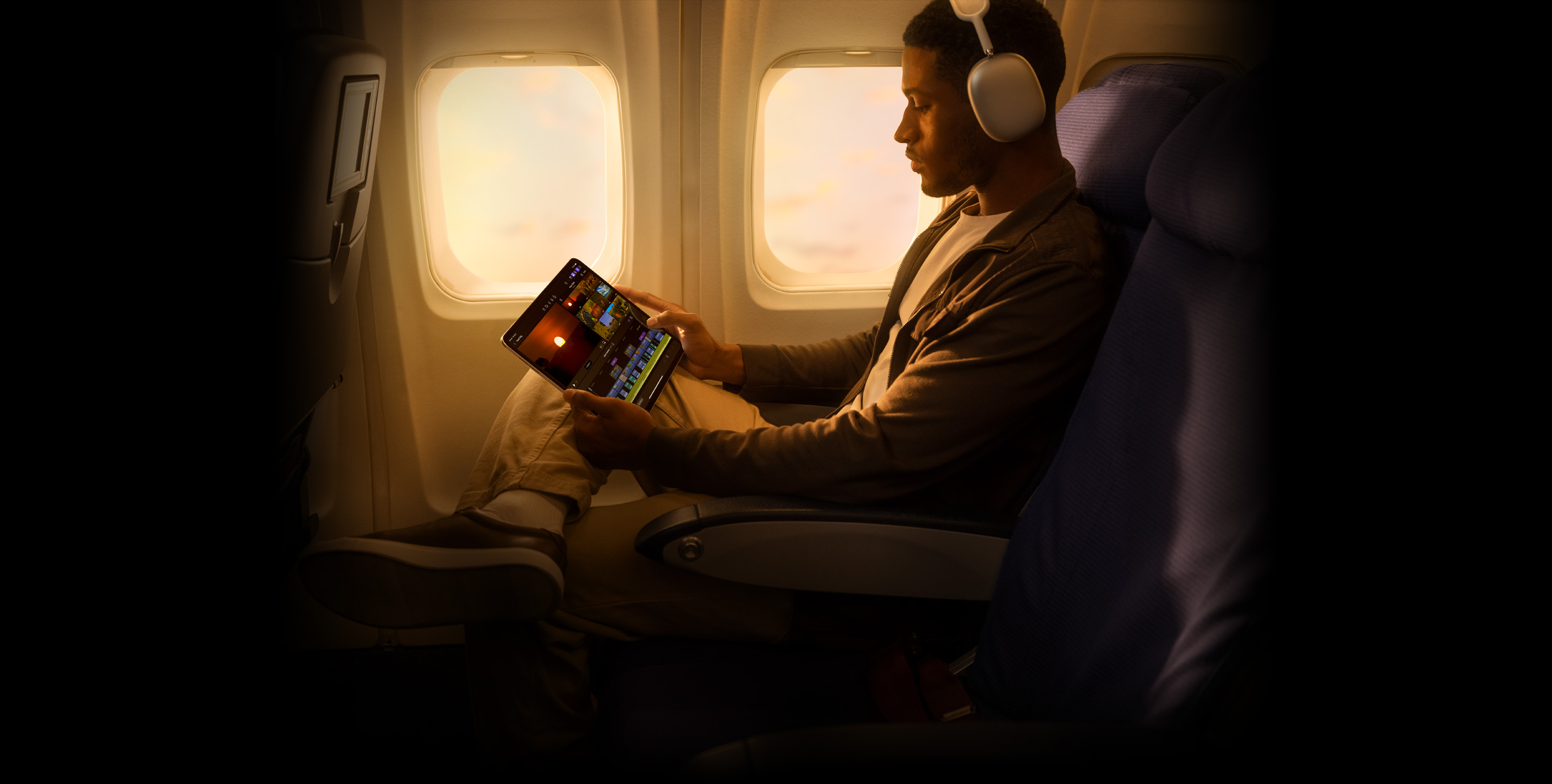 A person wearing headphones edit footage in Final Cut Pro for iPad on an iPad Pro.