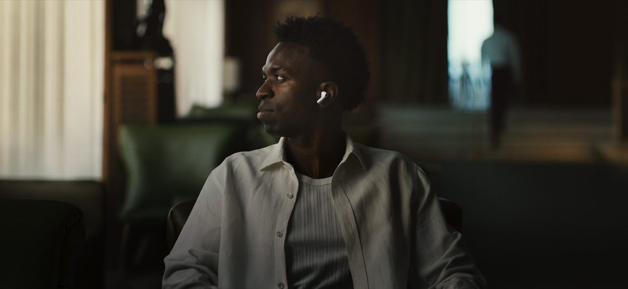 白いシャツを着た人物が横を向いている。左のAirPods Pro 3のイヤーバッドが見えている