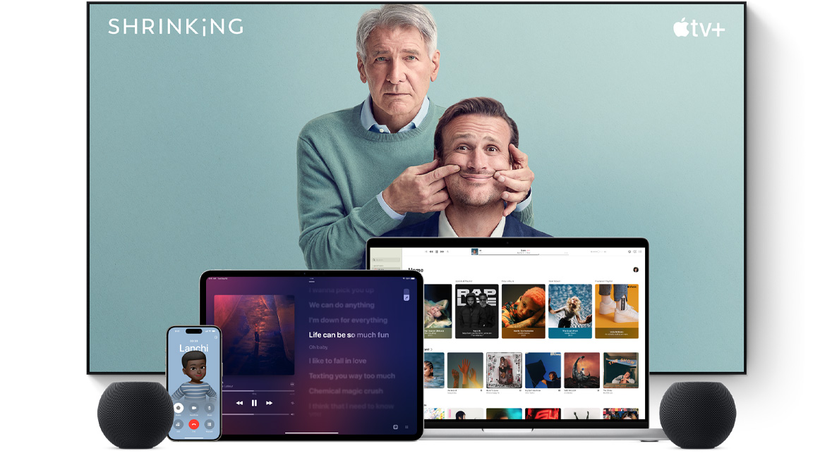Large flat screen television showing two male characters from the Apple TV+ series shrinking. A MacBook Pro, an iPad, an iPhone, and a Midnight HomePod mini are arranged in front.