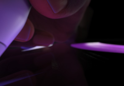 Korisnik drži Apple Pencil Pro u položaju za pisanje. Vršak je pritisnut na zaslon koji prikazuje crtanje debljih poteza u žarko ljubičastoj boji.