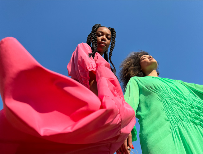 Uma foto de duas mulheres em vestidos coloridos, tirada com a câmera principal.