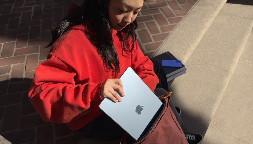 Een student bergt MacBook Air op in een rugzak