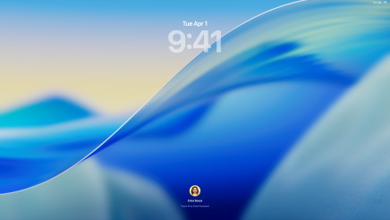 Three Mac models facing forward, 16″ MacBook Pro in Silver at left with Phone app on screen showing recent contacts, 24″ iMac in Blue in centre macOS Tahoe wallpaper on screen, and 13″ MacBook Air in Midnight at right, screen shows Spotlight Search over the desktop with Liquid Glass versions of the Dock and various widgets such as Calendar, Clock and Weather